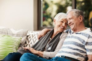 Older couple sitting on a couch, smiling